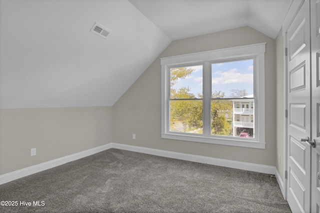 101 SE 68th St, Oak Island, NC 28465 - additional living space with dark carpet, visible vents, baseboards, and vaulted ceiling