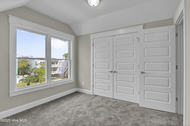 101 SE 68th St, Oak Island, NC 28465 - unfurnished bedroom featuring a closet, baseboards, vaulted ceiling, and carpet floors