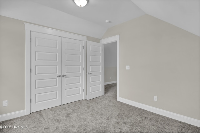 101 SE 68th St, Oak Island, NC 28465 - unfurnished bedroom featuring a closet, baseboards, lofted ceiling, and carpet