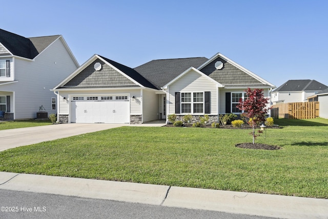 craftsman-style home with a garage, fence, stone siding, a front lawn, and concrete driveway