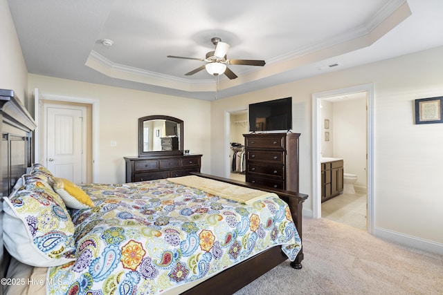 bedroom with crown molding, light colored carpet, a spacious closet, visible vents, and a raised ceiling
