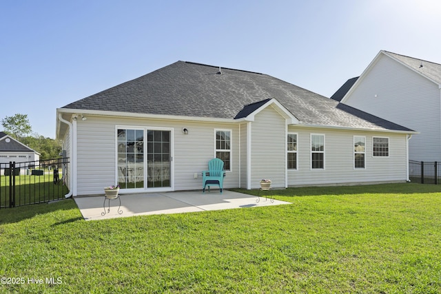 back of house with a patio, roof with shingles, a yard, and fence