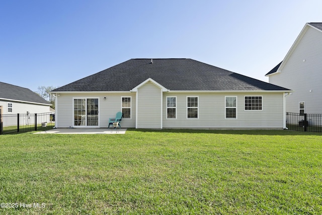 rear view of house with a shingled roof, a yard, a patio area, and a fenced backyard
