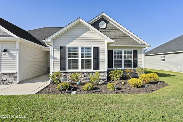 view of front facade with a front yard and stone siding
