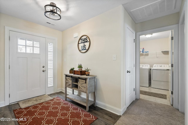 entryway featuring washing machine and clothes dryer, baseboards, and visible vents