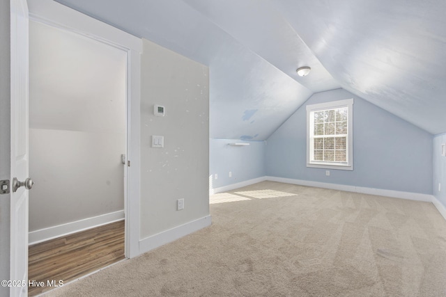 bonus room with carpet flooring, baseboards, and vaulted ceiling