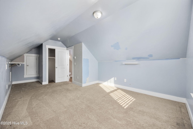 additional living space featuring baseboards, carpet, and vaulted ceiling