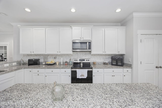 kitchen with appliances with stainless steel finishes, ornamental molding, backsplash, and white cabinetry