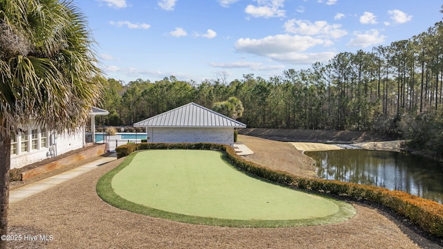 view of home's community with a water view, a wooded view, and a pool