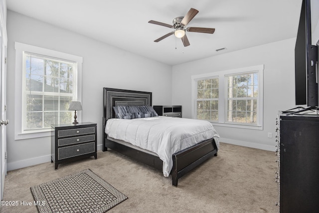 bedroom featuring baseboards, ceiling fan, light carpet, and visible vents