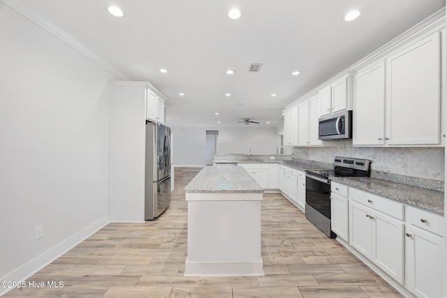 kitchen with ceiling fan, visible vents, a sink, a peninsula, and stainless steel appliances