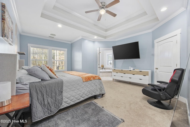 carpeted bedroom featuring crown molding, ensuite bathroom, and a tray ceiling