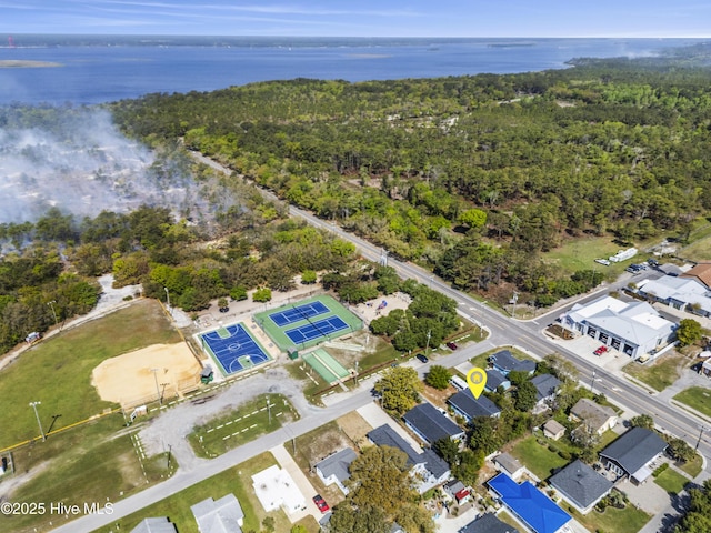 birds eye view of property featuring a water view, a wooded view, and a residential view