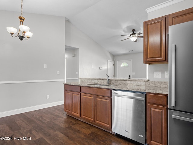 kitchen with dark wood finished floors, a sink, ceiling fan with notable chandelier, lofted ceiling, and stainless steel appliances