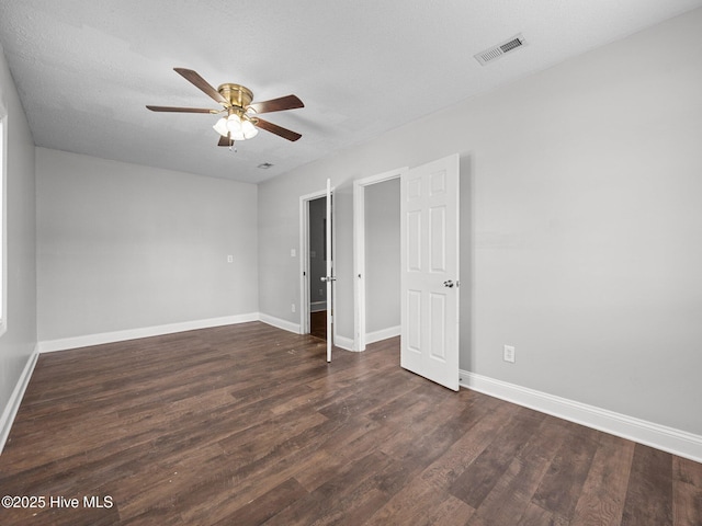 unfurnished bedroom featuring baseboards, dark wood-style floors, and visible vents
