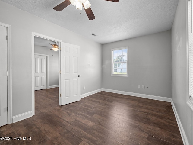 unfurnished bedroom featuring ceiling fan, a textured ceiling, visible vents, wood finished floors, and baseboards