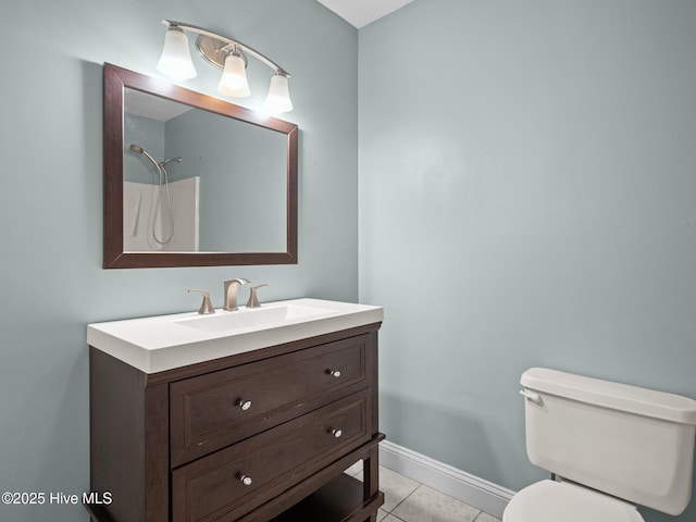 bathroom featuring vanity, baseboards, tile patterned floors, and toilet