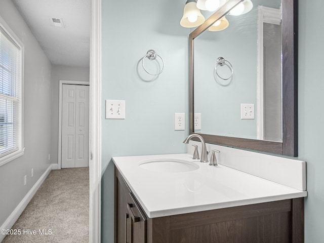 bathroom with vanity, baseboards, a chandelier, and visible vents