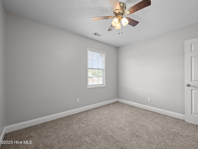 spare room featuring visible vents, baseboards, ceiling fan, a textured ceiling, and carpet flooring