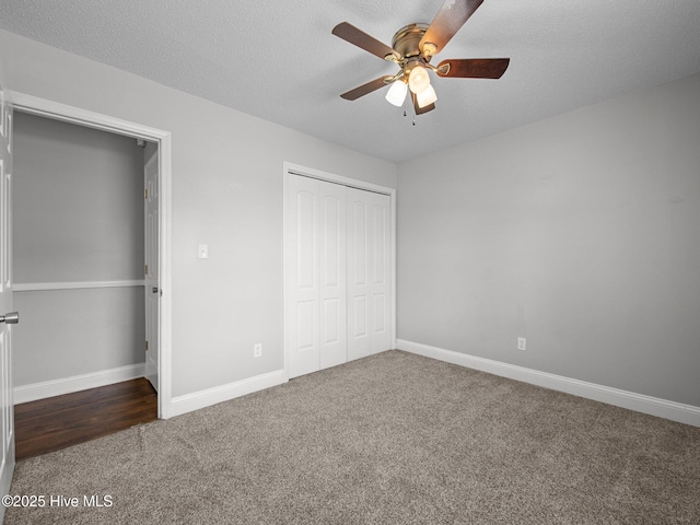 unfurnished bedroom with a ceiling fan, a textured ceiling, carpet floors, baseboards, and a closet