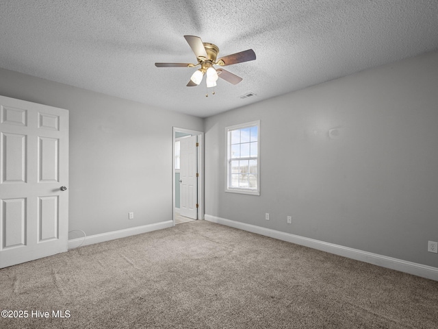 unfurnished bedroom featuring baseboards, carpet flooring, a textured ceiling, and visible vents