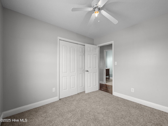 unfurnished bedroom with baseboards, carpet, ceiling fan, and a closet