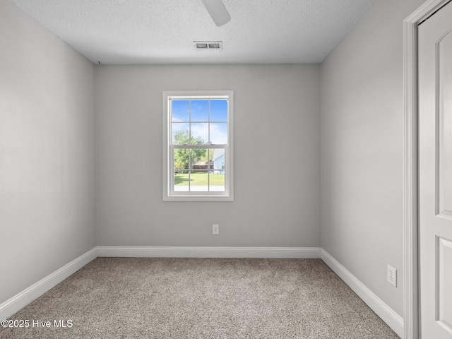 empty room featuring carpet flooring, a textured ceiling, and baseboards