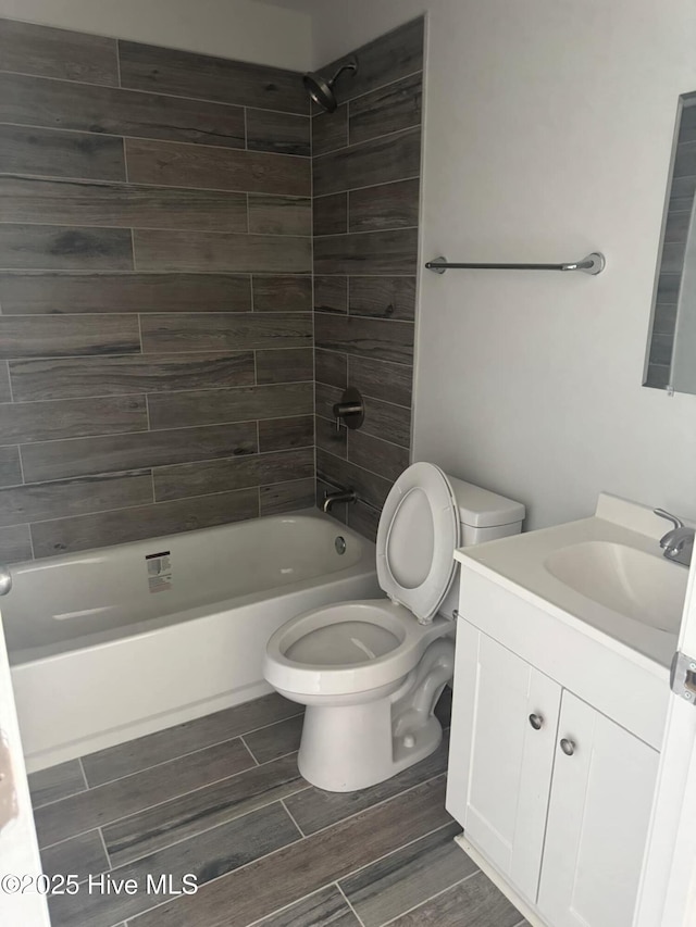 bathroom featuring toilet, shower / bathtub combination, vanity, and wood tiled floor