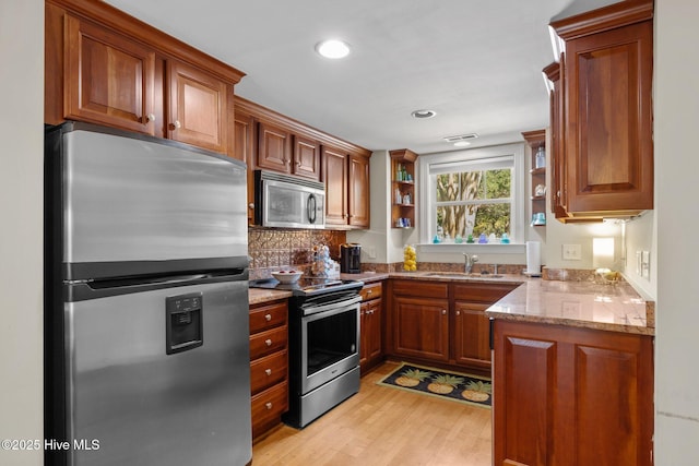 1308 Ann St Unit 16, Beaufort, NC 28516 - kitchen featuring appliances with stainless steel finishes, open shelves, a sink, light stone countertops, and brown cabinetry