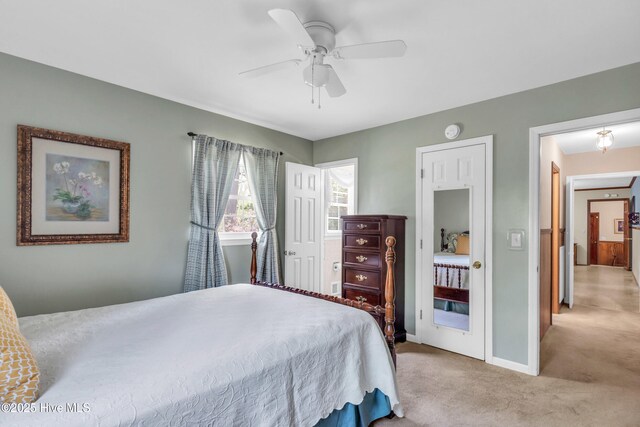 bedroom featuring light carpet, baseboards, and ceiling fan