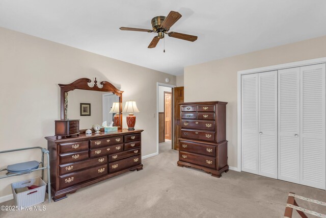 bedroom featuring a closet, baseboards, ceiling fan, and light colored carpet