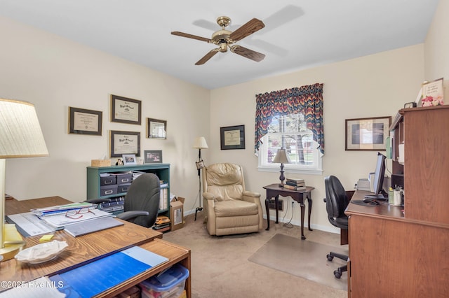 carpeted home office featuring a ceiling fan