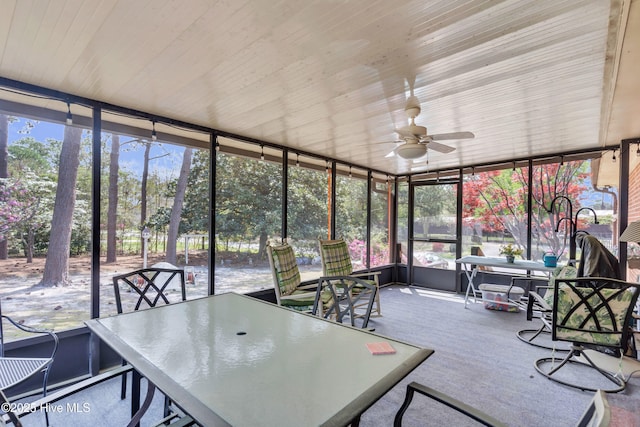 sunroom / solarium with ceiling fan, outdoor dining area, and a wealth of natural light
