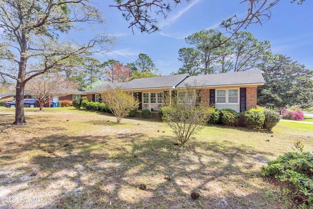 ranch-style house with a front yard and brick siding
