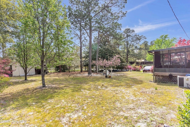 view of yard with central AC unit and a sunroom