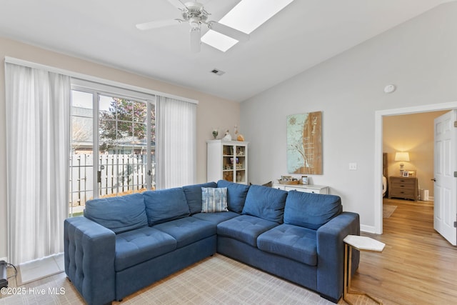 5006 Carleton Dr Unit 90, Wilmington, NC 28403 - living room featuring light wood-type flooring, a ceiling fan, baseboards, high vaulted ceiling, and a skylight