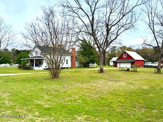1885 NC-306, Grantsboro, NC 28529 - view of grassy yard featuring a garage, a barn, and an outdoor structure