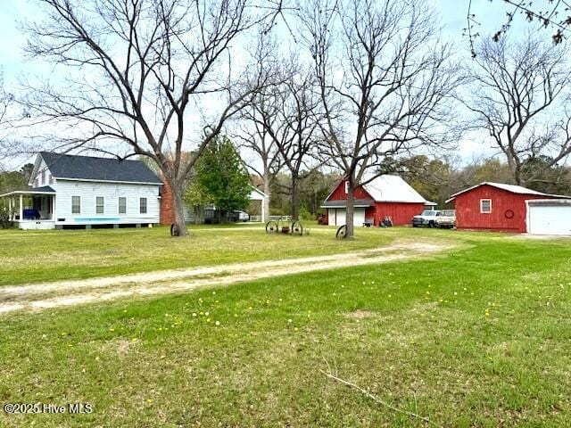 1885 NC-306, Grantsboro, NC 28529 - view of grassy yard featuring a garage, an outbuilding, and driveway