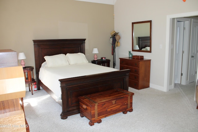 bedroom with light carpet and baseboards