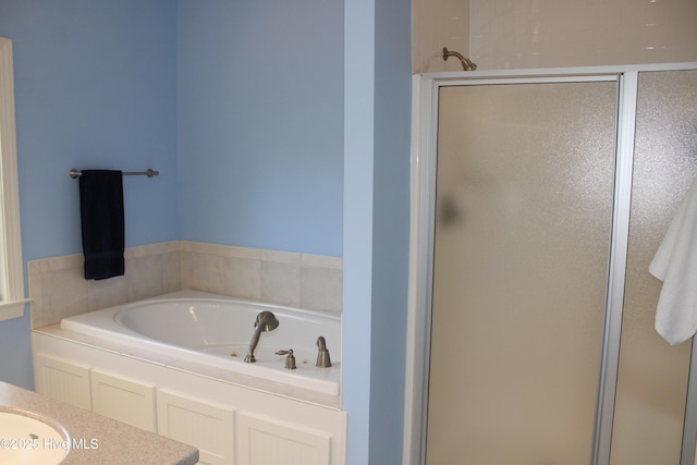 bathroom featuring a bath, a sink, and a shower stall