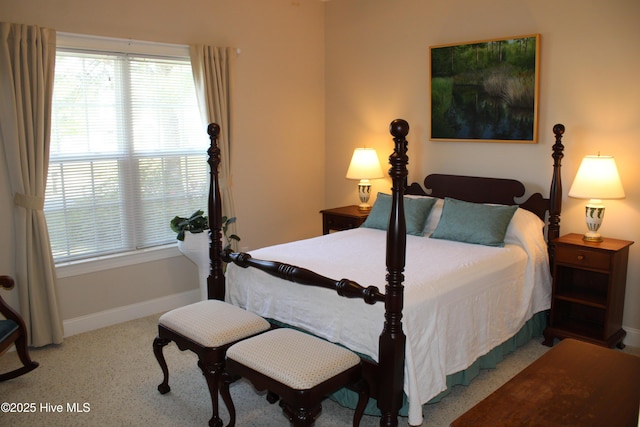 carpeted bedroom featuring baseboards and multiple windows