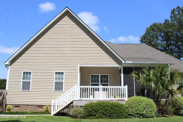 rear view of house featuring a porch, crawl space, and a shingled roof