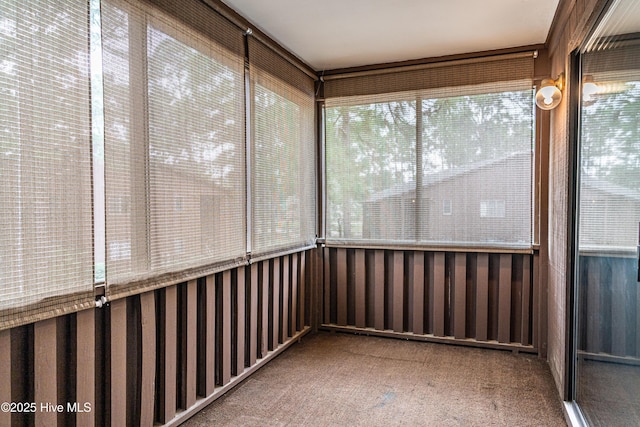 unfurnished sunroom featuring carpet flooring