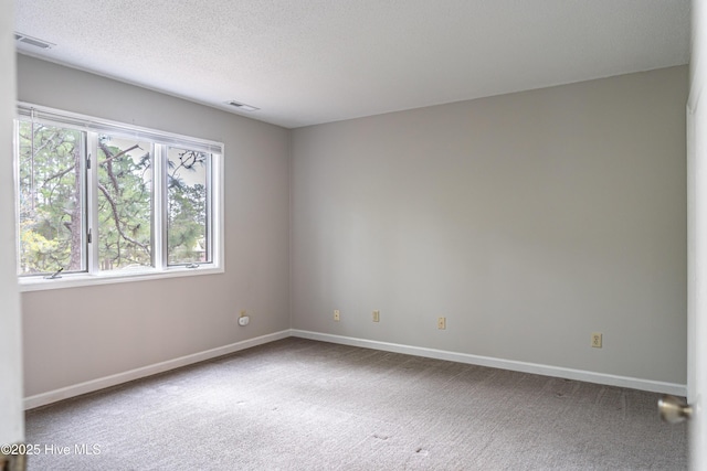 unfurnished room with a healthy amount of sunlight, visible vents, and carpet