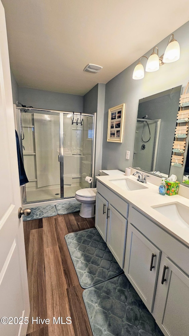 1905 Coleman Lake Dr, Calabash, NC 28467 - bathroom featuring wood finished floors, a shower stall, double vanity, and toilet