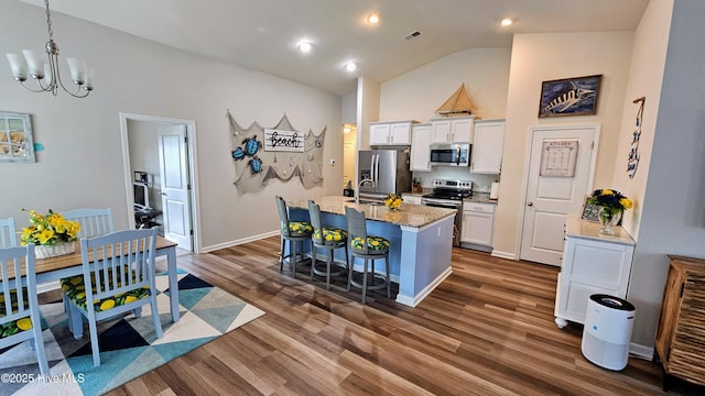 1905 Coleman Lake Dr, Calabash, NC 28467 - kitchen featuring stainless steel appliances, white cabinetry, a kitchen bar, a center island with sink, and a chandelier