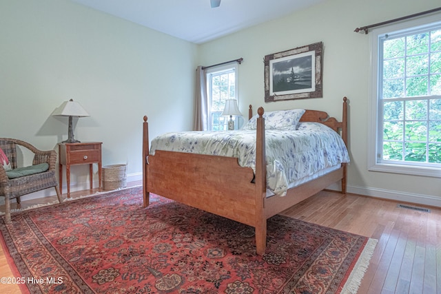 bedroom featuring wood finished floors, baseboards, and a ceiling fan