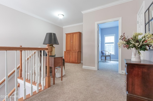 hallway featuring crown molding, baseboards, and light carpet