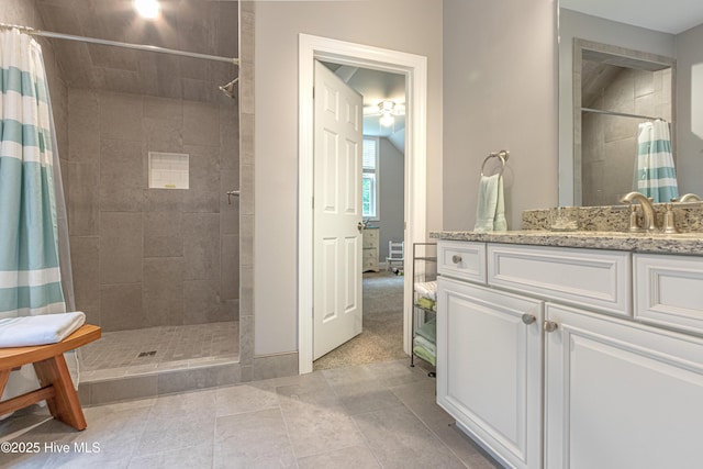 bathroom featuring a tile shower and vanity