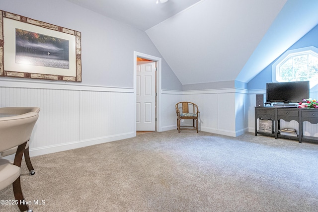 bonus room with lofted ceiling, carpet flooring, and a wainscoted wall